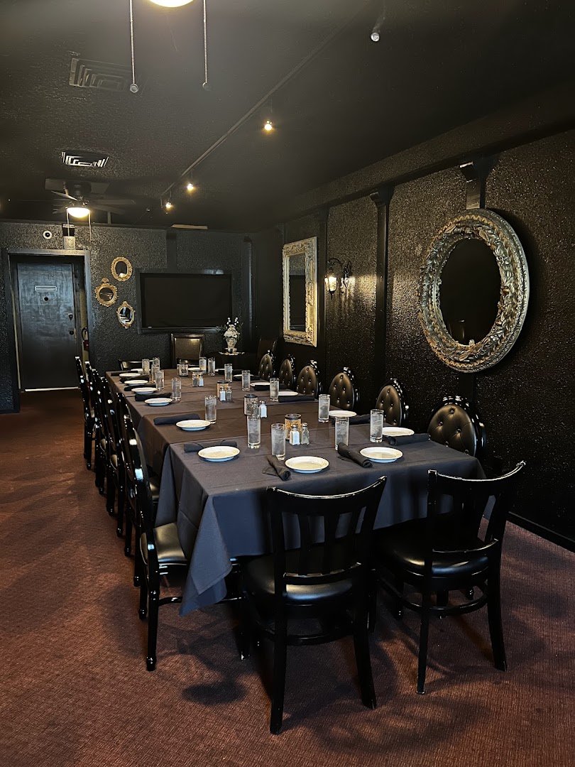 Dim steakhouse dining room with warm lighting.